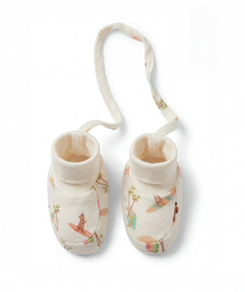 Pair of baby booties with a strap on a white background